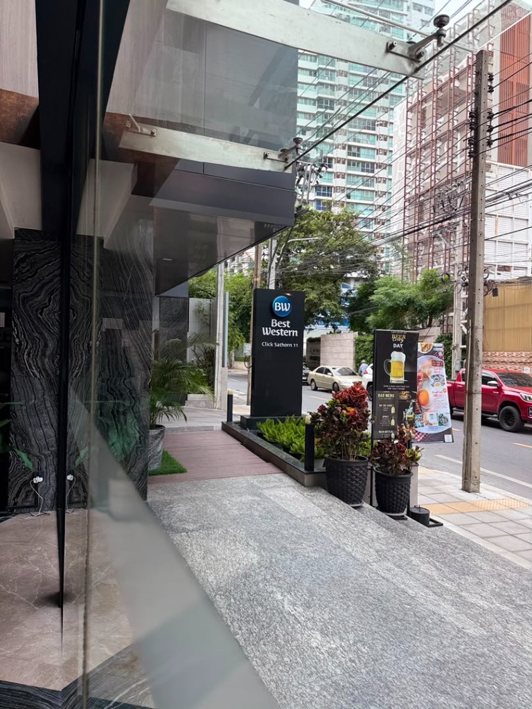 Entrance of Best Western Click Sathorn 11 with the hotel sign on the sidewalk