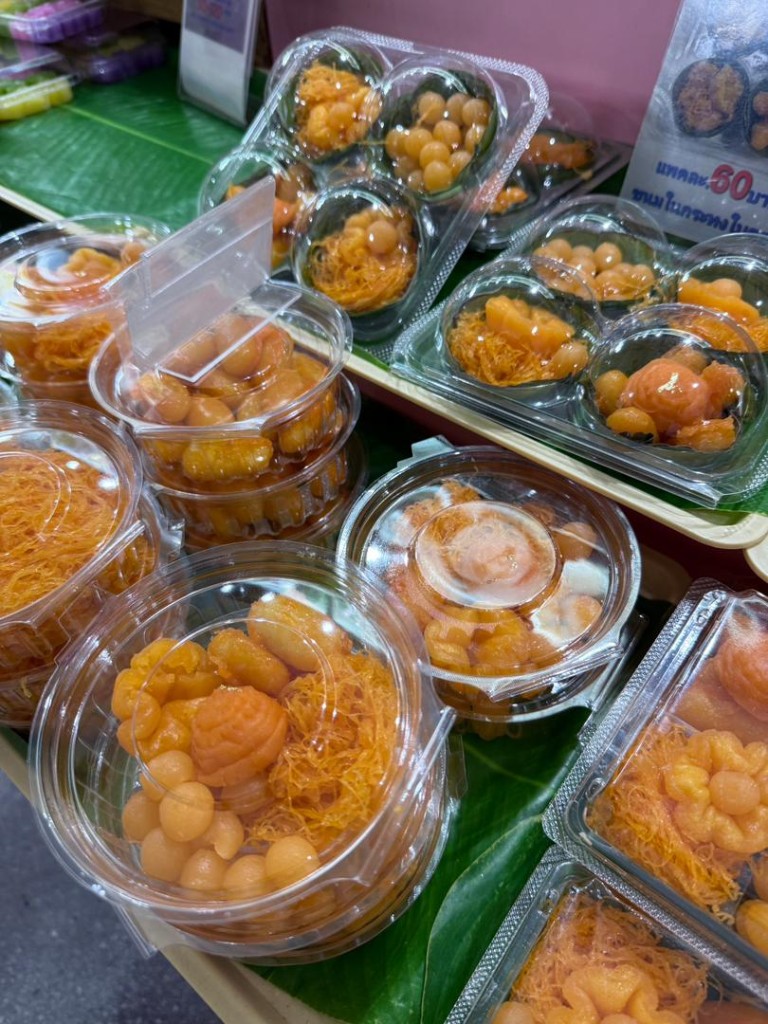 Thai egg-yolk desserts in plastic packs on banana leaves at Samyan Market