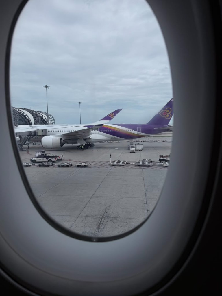 View from an aircraft window of a Thai Airways plane parked at Suvarnabhumi Airport
